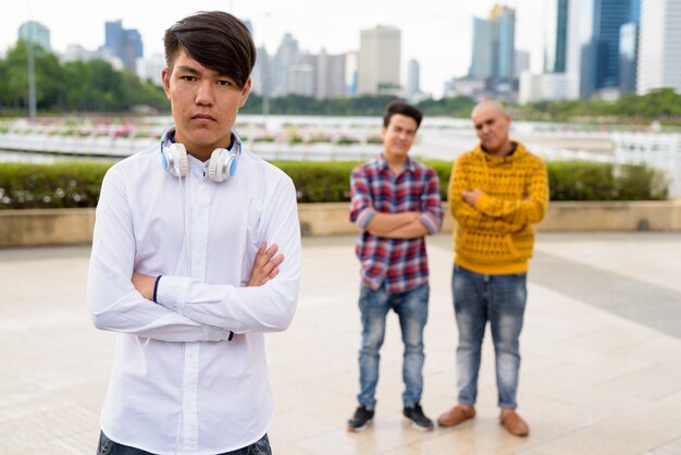 Portrait de trois jeunes hommes asiatiques ensemble se détendre dans le parc de Bangkok, Thaïlande