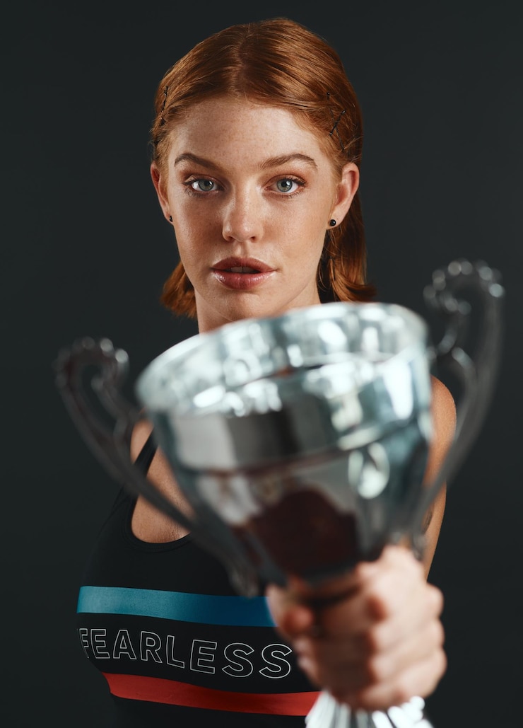 Photo portrait de trophée et championne sportive féminine avec une réalisation gagnante ou un succès pour la compétition précieuse forme physique et athlète féminin avec un prix pour un concours ou un tournoi avec fierté sur un fond noir