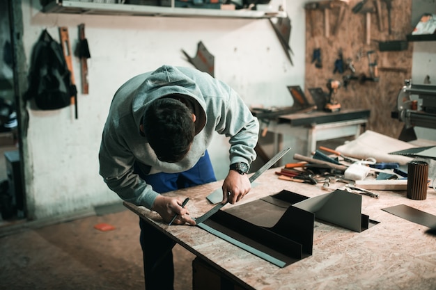 Portrait d'un véritable forgeron ferblantier d'un homme qui travaille le métal dans son atelier,