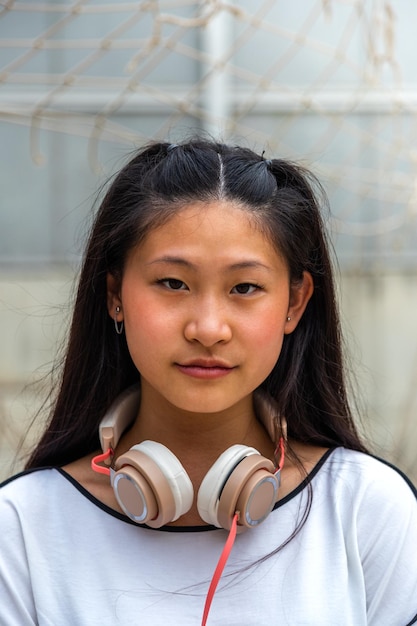 Portrait vertical d'une adolescente asiatique regardant la caméra. Notion de mode de vie.