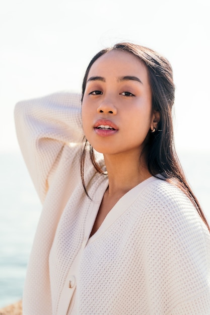 Portrait vertical d'une jeune femme asiatique regardant avec une expression sensuelle, un concept de beauté et de pureté