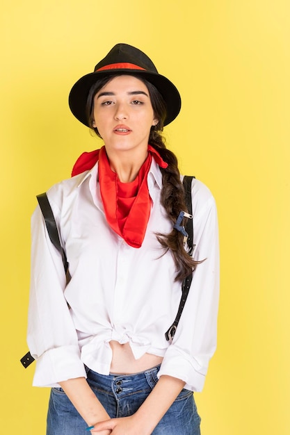 Portrait vertical d'une jeune femme confiante debout sur fond jaune Photo de haute qualité