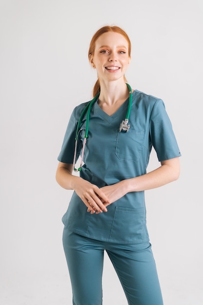 Portrait vertical d'une jeune femme médecin souriante en uniforme médical avec stéthoscope autour du cou