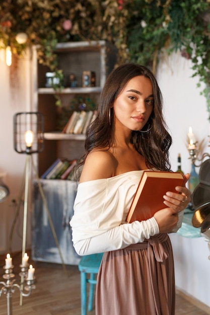 Portrait vertical de jeune femme tenant son livre et debout sur une photo de haute qualité