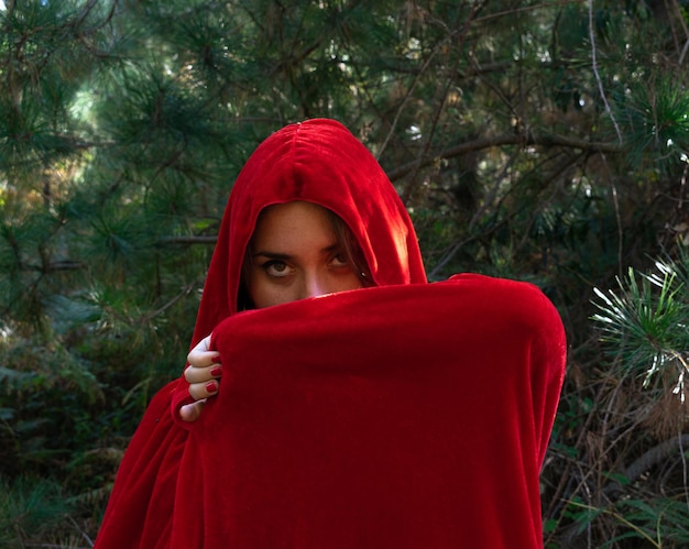 Photo portrait vertical d'une jolie fille avec une cape rouge