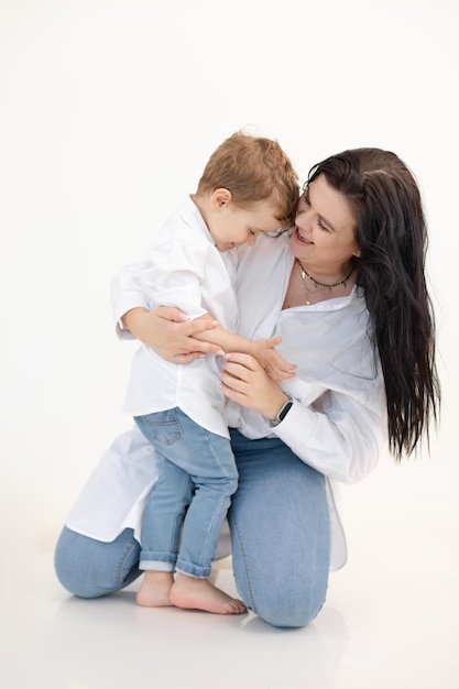 Portrait vertical de mère célibataire dark haired woman careing and holding little boy on floor fils embr