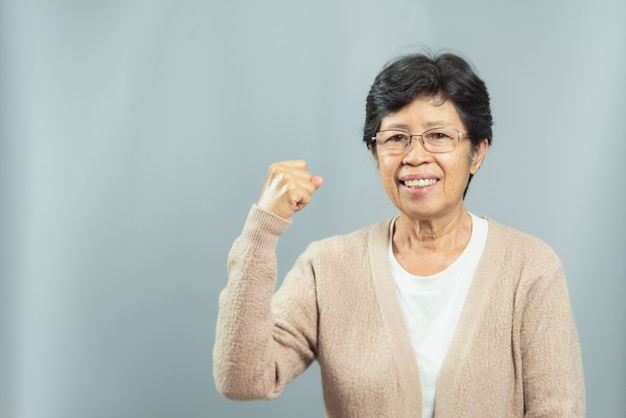 Portrait de vieille femme souriante sur fond gris