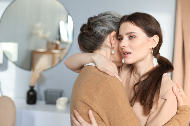 Portrait d'une vieille mère et d'une fille mûre s'embrassant à la maison. Bonnes relations de confiance. Notion de famille.