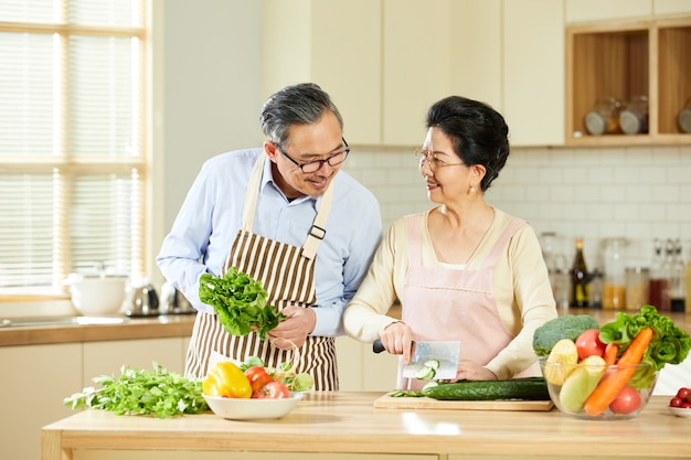 Portrait d'un vieux couple marié a l'air joyeux dans la salle de cuisine