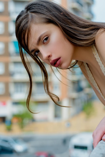 Portrait de ville de fille. Fille à la mode sur balcon. Mode de rue. Femme dans la ville moderne.