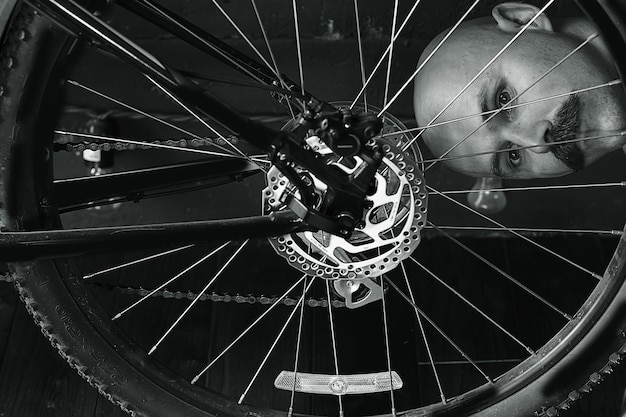 portrait vintage d'un homme moustachu réparant une roue de vélo, hipster excentrique