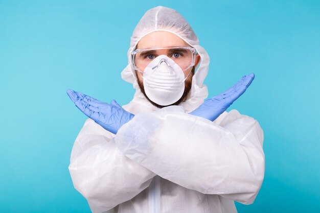 Photo portrait de virologue scientifique portant une combinaison de protection, des lunettes et un respirateur montrant stop