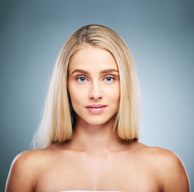 Portrait visage et beauté avec une femme modèle en studio sur fond gris pour promouvoir les soins de la peau naturels Cheveux bien-être et luxe avec une jeune femme séduisante à l'intérieur pour approuver les cosmétiques