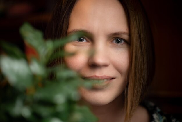 Portrait de visage d'une femme d'âge moyen dans les plantes vertes souriante Une femme dans la quarantaine état calme de relaxation visage heureux