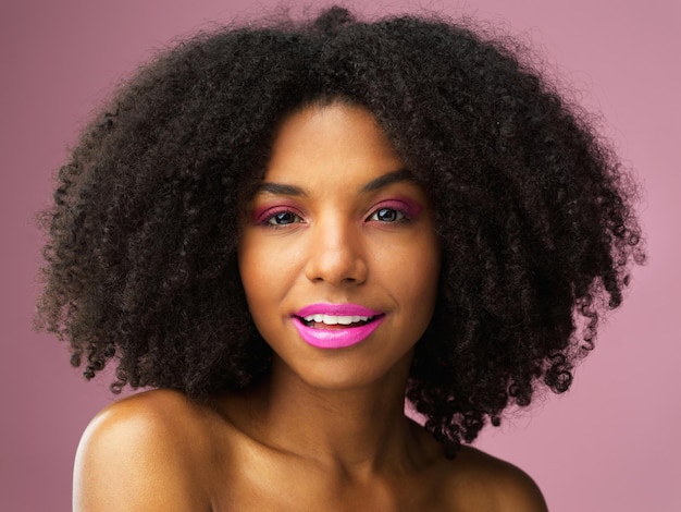 Portrait de visage soins capillaires et femme noire avec rouge à lèvres en studio isolé sur fond rose pour les soins de la peau Cosmétiques de maquillage de beauté et modèle féminin africain avec traitement de salon pour coiffure afro