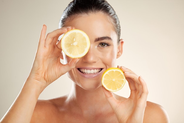 Portrait de visage de soins de la peau et femme heureuse avec du citron pour le bien-être naturel de la désintoxication des fruits ou la lueur de la beauté du visage Spa salon dermatologie modèle de soins de santé et de nutritionniste avec un produit alimentaire à base de vitamine c