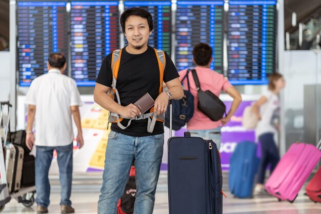 Portrait de voyageur asiatique avec bagages avec passeport permanent sur le tableau de bord