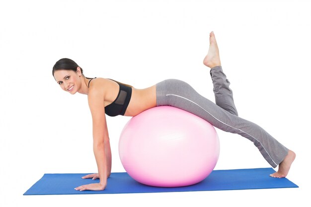 Portrait de vue de côté d&#39;une femme en forme qui s&#39;étend sur ballon de fitness