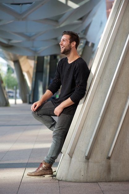 Portrait de vue de côté d&#39;un homme souriant, debout à l&#39;extérieur