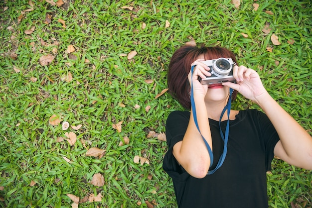 Photo portrait vue de dessus d'une jolie jeune femme reposante sur une herbe