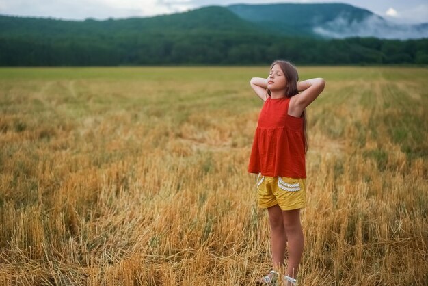 Portrait de vue latérale d'une belle fille heureuse respirant de l'air frais dans un champ à l'extérieur Photo de haute qualité