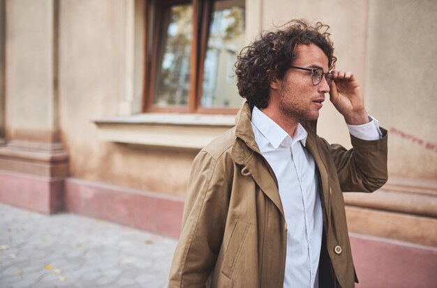 Portrait de vue latérale horizontale d'un jeune homme d'affaires avec des lunettes posant à l'extérieur Étudiant de sexe masculin dans la rue d'automne