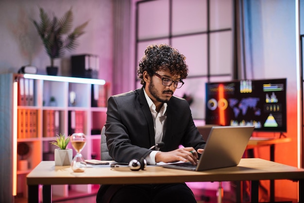 Portrait de vue latérale d'un jeune gestionnaire barbu intelligent et élégant expérimenté souriant dans les lunettes