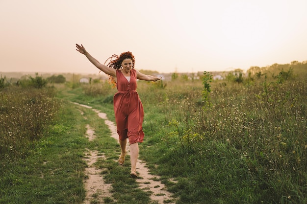 Portraits d'une charmante femme rousse avec un joli visage Fille posant pour la caméra sur le terrain au coucher du soleil