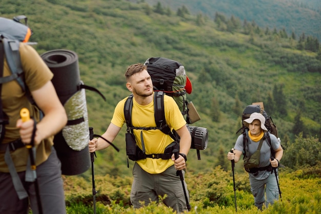 Portraits d'un groupe d'amis grimpant du pied de la montagne à son point culminant sélectif