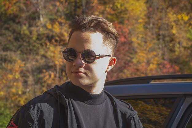 Portraits d'un jeune homme par forêt d'automne.