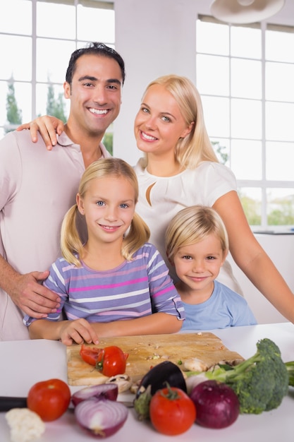 Posant une famille coupant des légumes ensemble