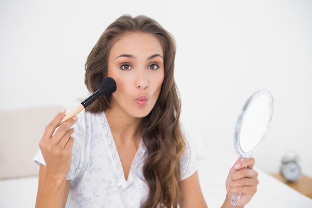 Photo posant une jolie brune tenant une brosse et un miroir