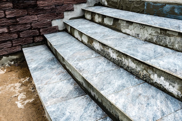 Pose de carrelage dans les escaliers de la maison.