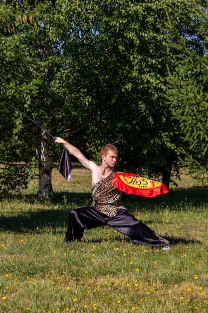 Photo pose indicative de wushu, un garçon avec une arme