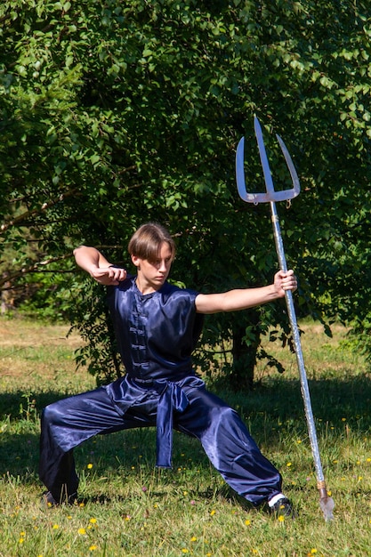 Photo pose indicative de wushu, un garçon avec une arme