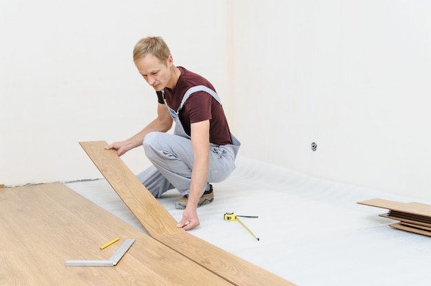 Pose d'une lame de parquet stratifié.