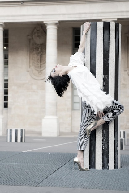 Pose de mannequin à paris, france. Femme de mode à lunettes de soleil sur la place.