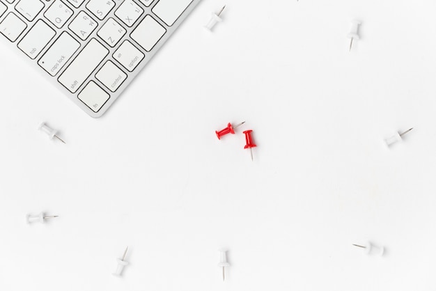 Pose plate de la punaise blanche de l’espace de travail, de la punaise rouge et du clavier avec espace sur fond blanc