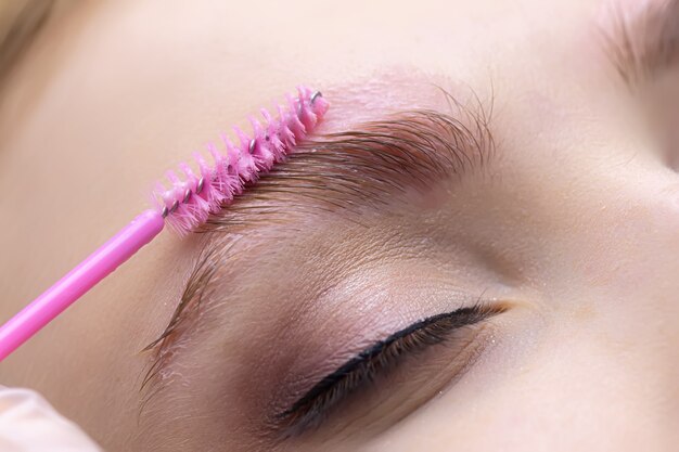 pose des sourcils du modèle avec une brosse avant la procédure de stratification