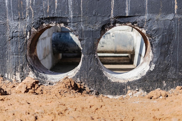 Pose de tuyaux souterrains dans une chambre en béton Installation d'une conduite d'eau principale sur le chantier Construction de fosses d'eaux pluviales vanne d'égout système sanitaire et station de pompage