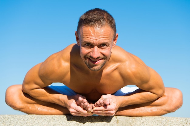 La position de yoga m'aide à réussir. Professeur de yoga heureux. Sourire heureux homme faisant du sport. L'homme musclé jouit d'une bonne santé. Puissance musculaire. Succès dans le sport. Apaiser l'esprit et renforcer la santé.