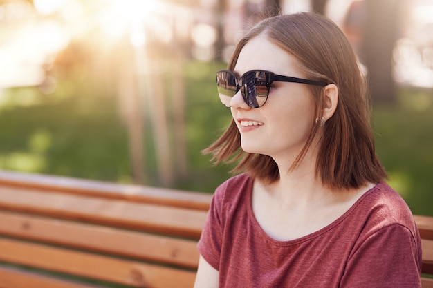 Positive jeune belle femme avec une coiffure à la mode