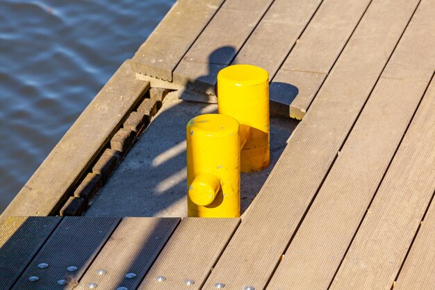 Poste d'amarrage jaune sur le pont au bord de la mer