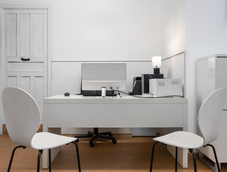 Photo poste de travail avec un bureau, deux chaises, une imprimante et un ordinateur tout en noir et blanc