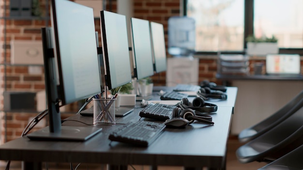 Photo poste de travail de service client vide pour aider les clients de télémarketing, technologie moderne de centre d'appels pour l'assistance et le support des ventes. aucune personne au bureau avec des moniteurs et des écouteurs.