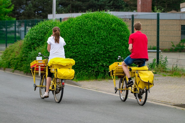 Postman riding son vélo cargo effectuant du courrier dans le quartier.