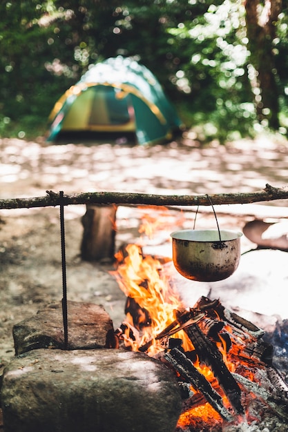 Le pot brûle près de la tente dans la forêt la nuit. Beau feu de camp dans un camp touristique à l'état sauvage.