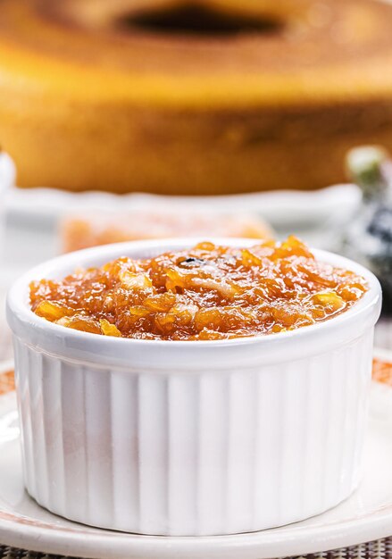 pot avec confiture de citrouille faite maison dessert typique brésilien lors des fêtes de juin et juillet en arrière-plan gâteau fuba et bonbons confits