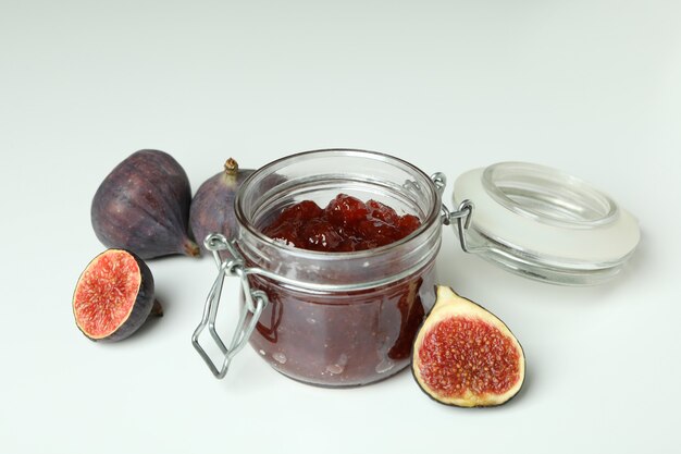 Photo pot avec confiture de figues et ingrédients sur fond blanc