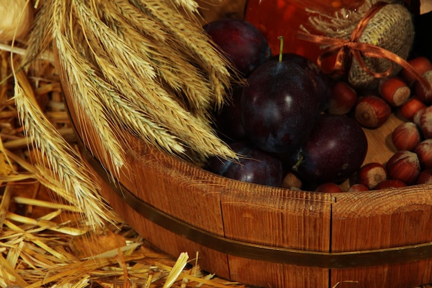 Pot de confiture avec noix et prunes dans une baignoire en bois se bouchent